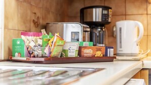 A kitchen counter with a tray of packaged food items, a coffee maker, and a microwave. - Remarkable 3-bed Apartment in London (London)