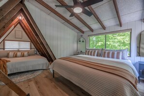 A bedroom with a loft bed, a large window with a view of greenery, and a ceiling fan. - Casa del Lago by Innsbrook Vacations! (Innsbrook)