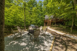 An outdoor seating area with Adirondack chairs and a fire pit, surrounded by trees and a wooden deck. - Casa del Lago by Innsbrook Vacations! (Innsbrook)