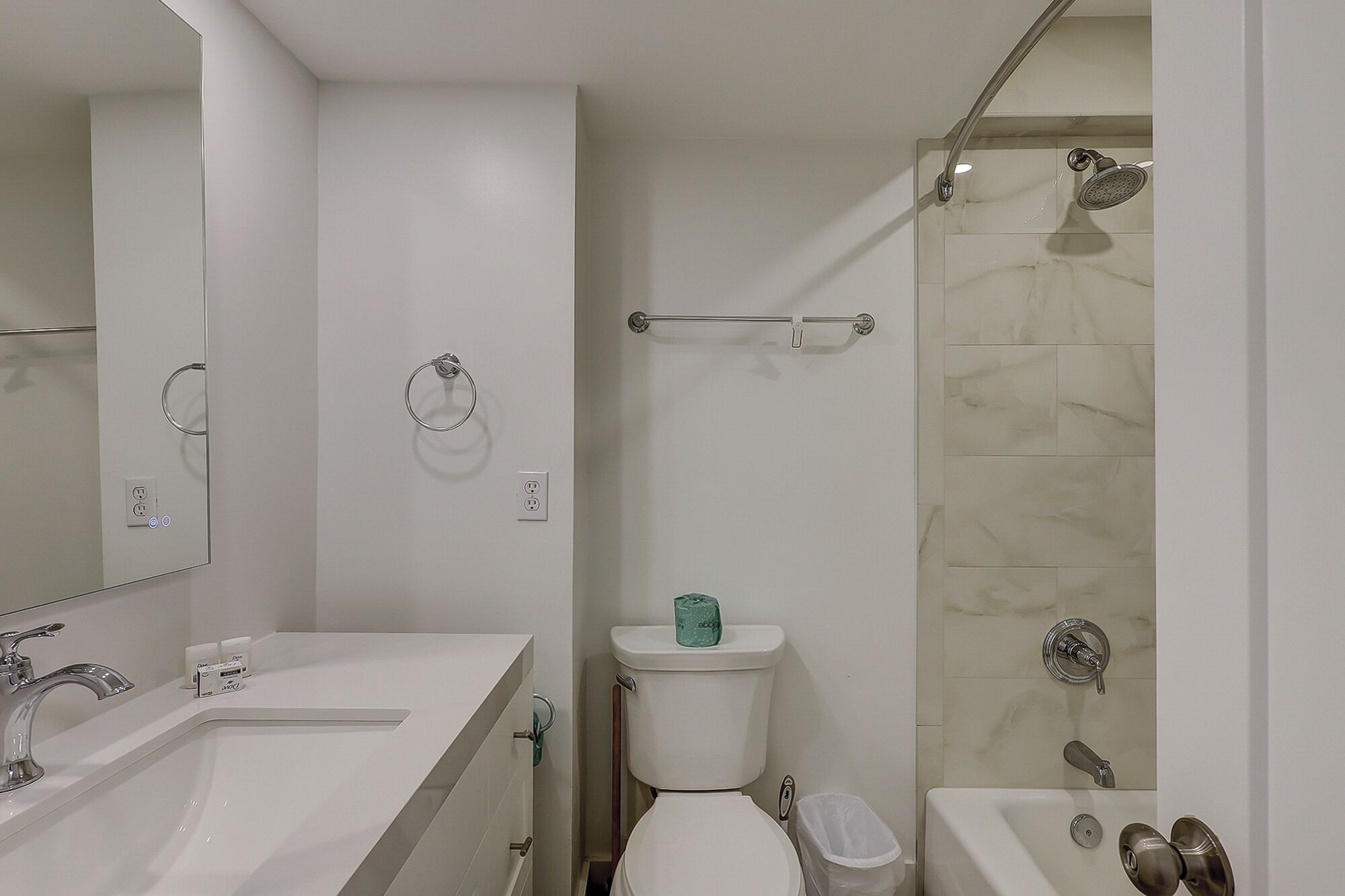 Un bany modern amb un lavabo, vàter i dutxa.