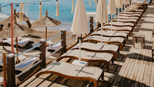 A beachside promenade with rows of sun loungers and umbrellas, overlooking the sea. - Echinus Lara Hotel (Antalya)