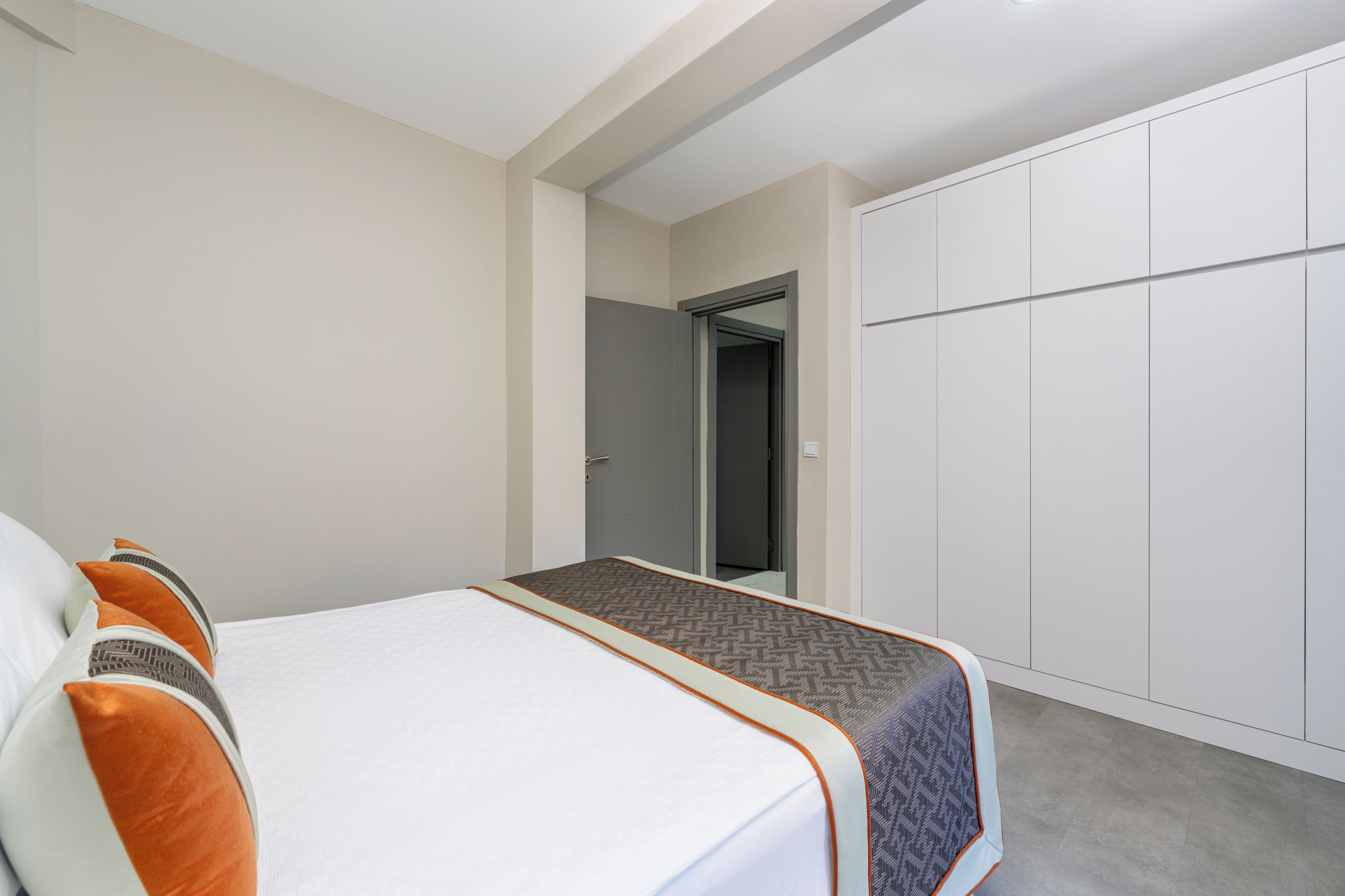 Una habitación de hotel con cama, armario y puerta que da a otra habitación.
