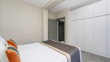 Una habitación de hotel con cama, armario y puerta que da a otra habitación.