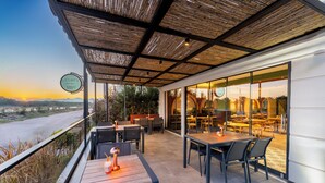 An outdoor dining area with tables and chairs, a view of the landscape, and a sign for 'Cliff's Cafe & Bar'. - Echinus Lara Hotel (Antalya)