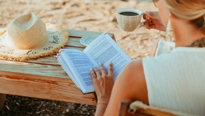 A person reading a book on a wooden bench by the beach with a straw hat and a cup of coffee. - Echinus Lara Hotel (Antalya)