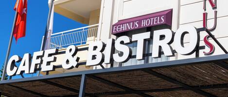 A building with a sign for 'Echinus Hotels' and 'Cafe & Bistro'.
