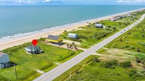 Vista aérea de una zona costera con carretera, playa y varios edificios.