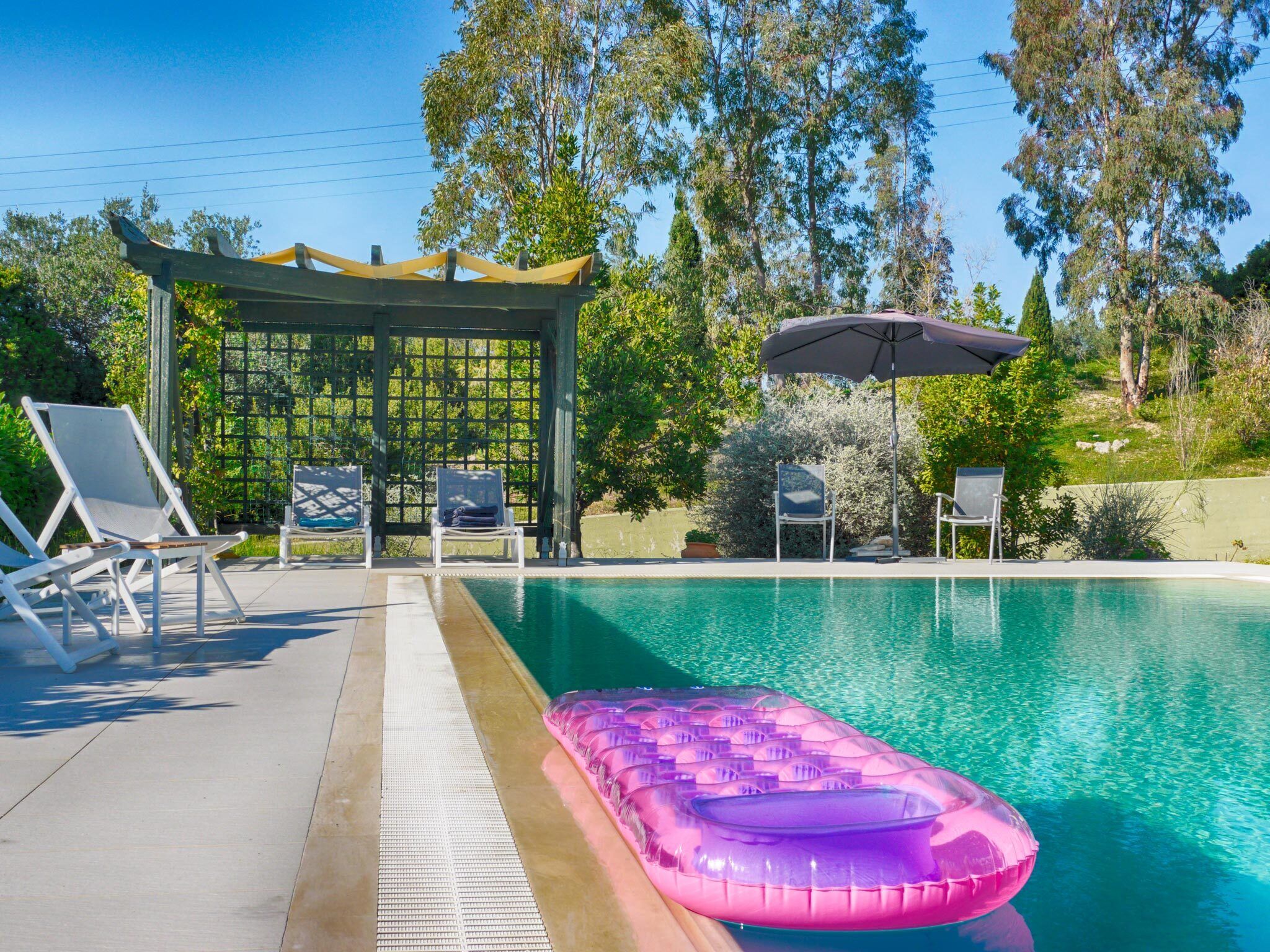 A swimming pool with lounge chairs and an inflatable pool float.
