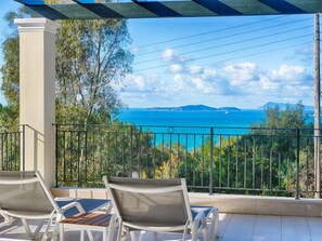 A balcony with two lounge chairs overlooking a coastal view. - Villa Afionas (Corfu)