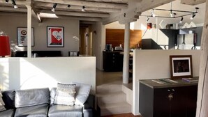 Ein modernes Wohnzimmer mit Ledersofa, Küchenzeile und Essbereich.