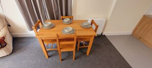 Cozy dining area with a wooden table and matching chairs, perfect for intimate meals.