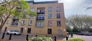Stylish urban residence with a brick facade, featuring balconies and a charming garden.
