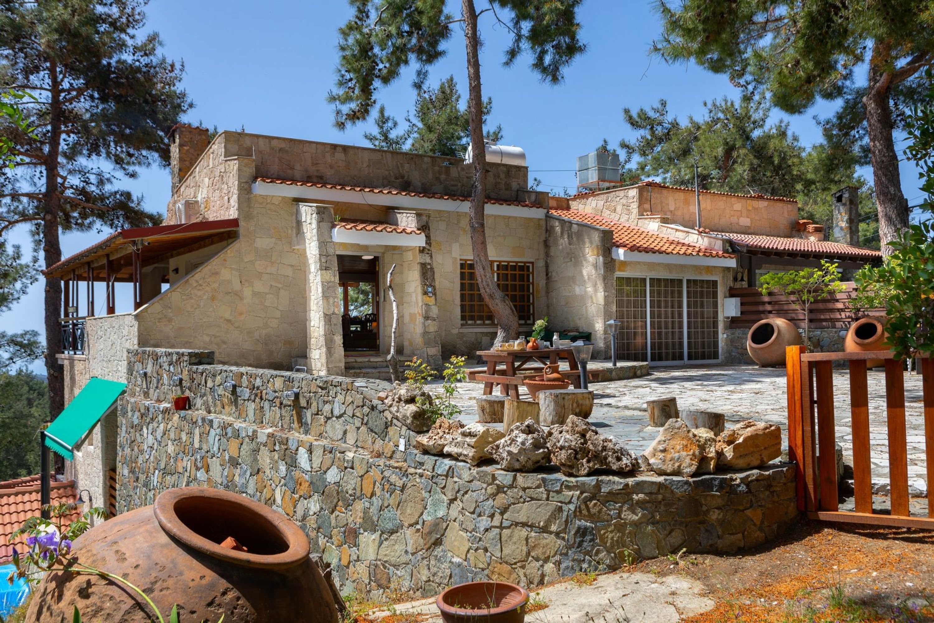 A stone house with a patio, outdoor seating, and a swimming pool.