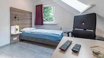Una camera da letto moderna con un letto, una scrivania e due telecomandi.