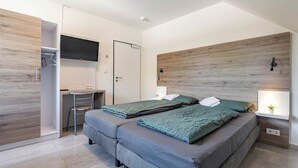 Un dormitorio moderno con dos camas, un escritorio y un televisor.