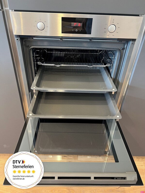 An oven with a digital display and multiple racks. - Weinberg.Holiday holiday home - 90 sqm (Traben-Trarbach)