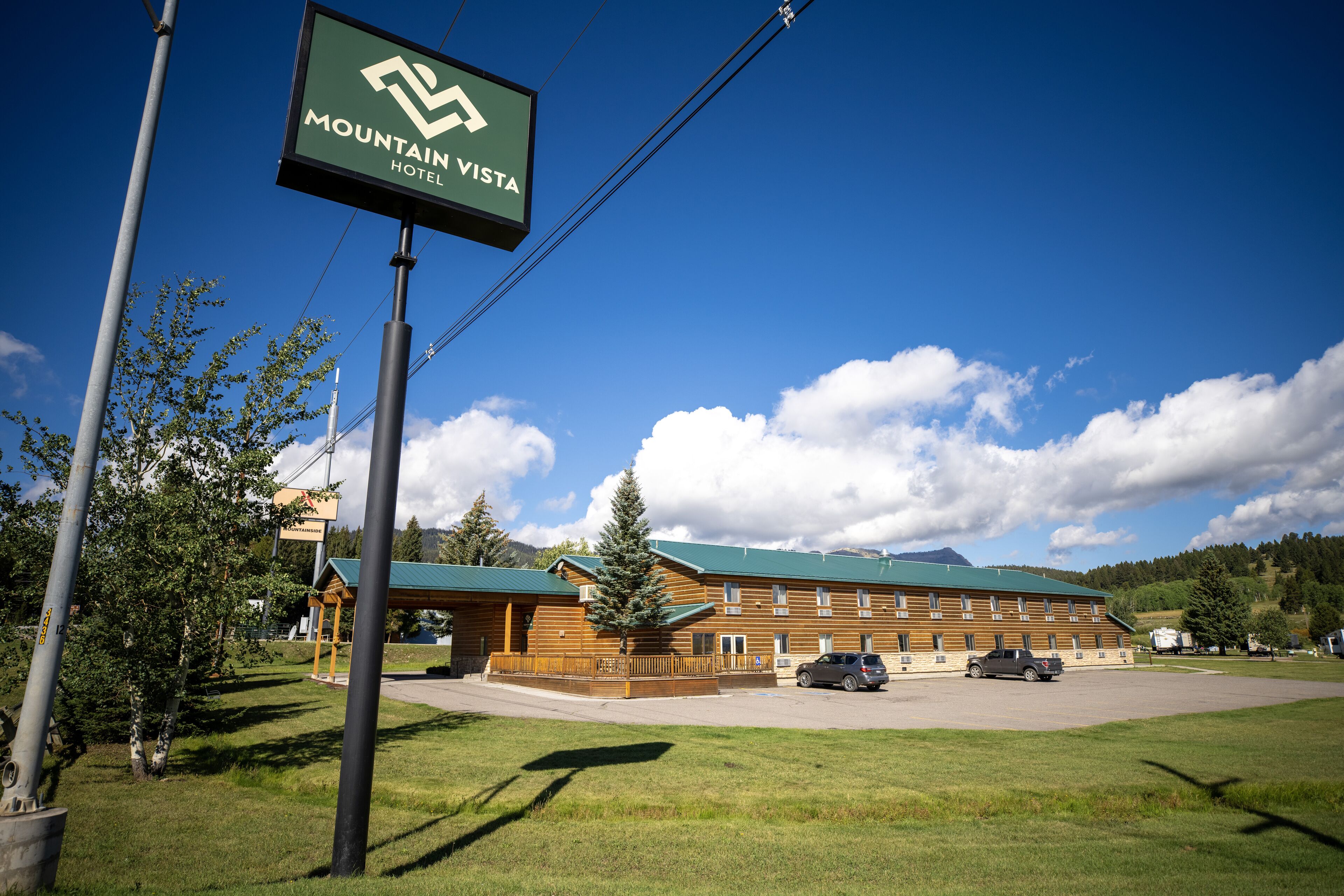 A Mountain Vista Hotel with a large building, parking lot, and surrounding greenery.