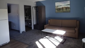 Una sala de estar moderna con un sofá, una mesa de centro y un cuadro en la pared.