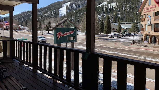 Una terraza de madera con un cartel que dice 'Powderosa Lodge' al fondo.