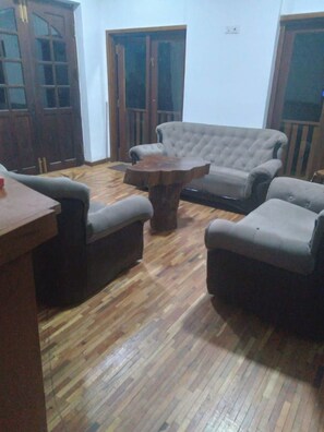 Un salon comprenant un canapé, une table basse et un plancher en bois.