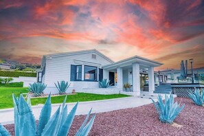 A modern house with a well-maintained lawn and agave plants.