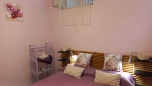 A bedroom with a bunk bed, a bedside table, a lamp, and a floral painting on the wall. - Delizia Caprese vacation home in Massa Lubrense with garden and Capri view (Massa Lubrense)
