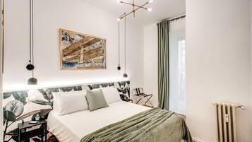 Une chambre à coucher moderne avec un grand lit, un tableau au-dessus du lit, un bureau et une chaise.