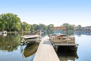 Guests can enjoy serene lake views from the dock, surrounded by lush greenery and picturesque buildings.