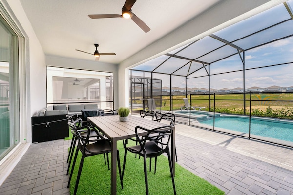 Enjoy al fresco dining on a spacious patio with pool views, perfect for relaxation and gatherings.