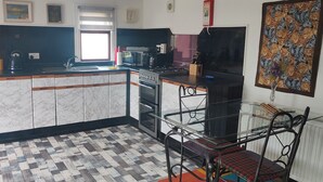 A kitchen with a marble countertop, a gas stove, a sink, and a window. - The Cabin Quiet, Relaxing and dog Friendly (Mauchline)