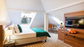 A modern hotel room with a bed, a desk, a TV, and a small balcony.