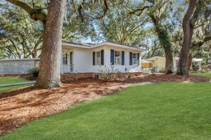 Stroll onto the charming front porch, surrounded by mature trees and a well-manicured lawn.