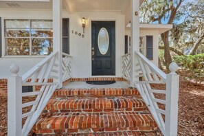 Traditional house with a brick staircase and white porch.