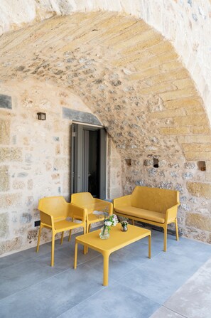 A stone-walled outdoor seating area with a table and two chairs. - Cardamilia Suites (West Mani)