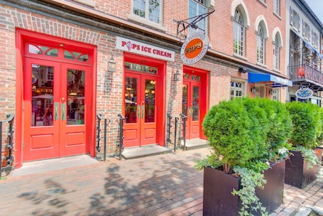 A brick building with red doors labeled "POPS ICE CREAM."