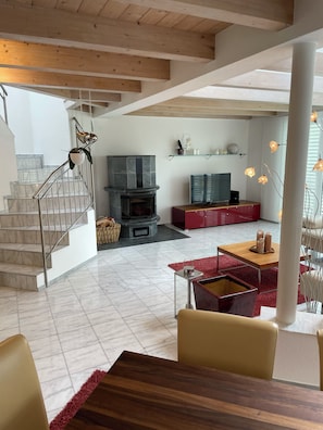 A spacious living area with a fireplace, a television, and a dining table.