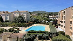 A residential area with a swimming pool surrounded by greenery and buildings. - T2 with balcony close to the sea. (Sainte-Maxime)