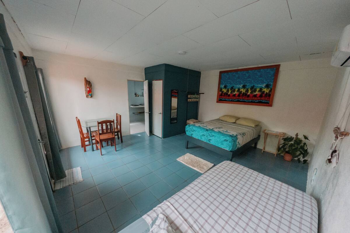A bedroom with a bed, a desk, and a chair.