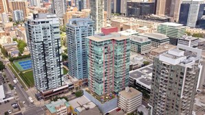 A high-rise building with multiple floors, surrounded by other tall buildings in an urban setting. - Chic DT Suite at Stampede w/ Free Parking, AC (Calgary)