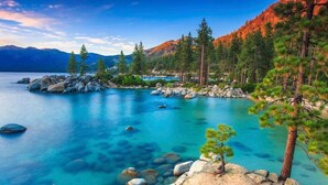 Un lago tranquilo rodeado de montañas y pinos.