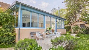 A conservatory with a glass roof, a dining table, and chairs outside. - Le laizon 1 by Interhome (Croissanville)