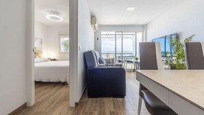 Una habitación de hotel moderna con cama, escritorio y vistas al balcón.