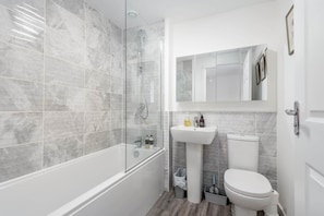 A modern bathroom with a glass-enclosed shower, a white pedestal sink, and a toilet. - Fort Avenue (No 31) | Guardbridge (Leuchars)