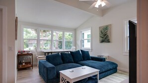 A modern living room with a sectional sofa, a coffee table, and a dining area with a table and chairs. - Newly Renovated Duplex- 4th Row (Hilton Head Island)