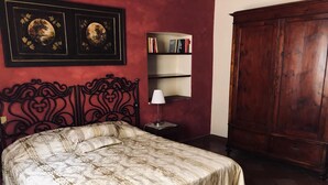 A bedroom with a bed, a bookshelf, a nightstand, and a wardrobe. - Old town, apartment with large kitchen (Toscana)