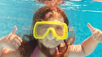 A person underwater with a pool in the background.