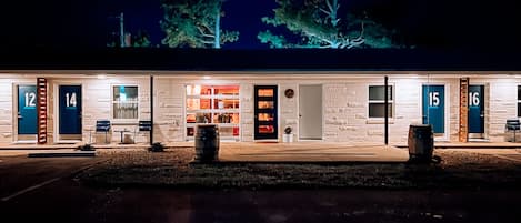 A motel with numbered rooms, a central open area with a bar, and a well-lit exterior.
