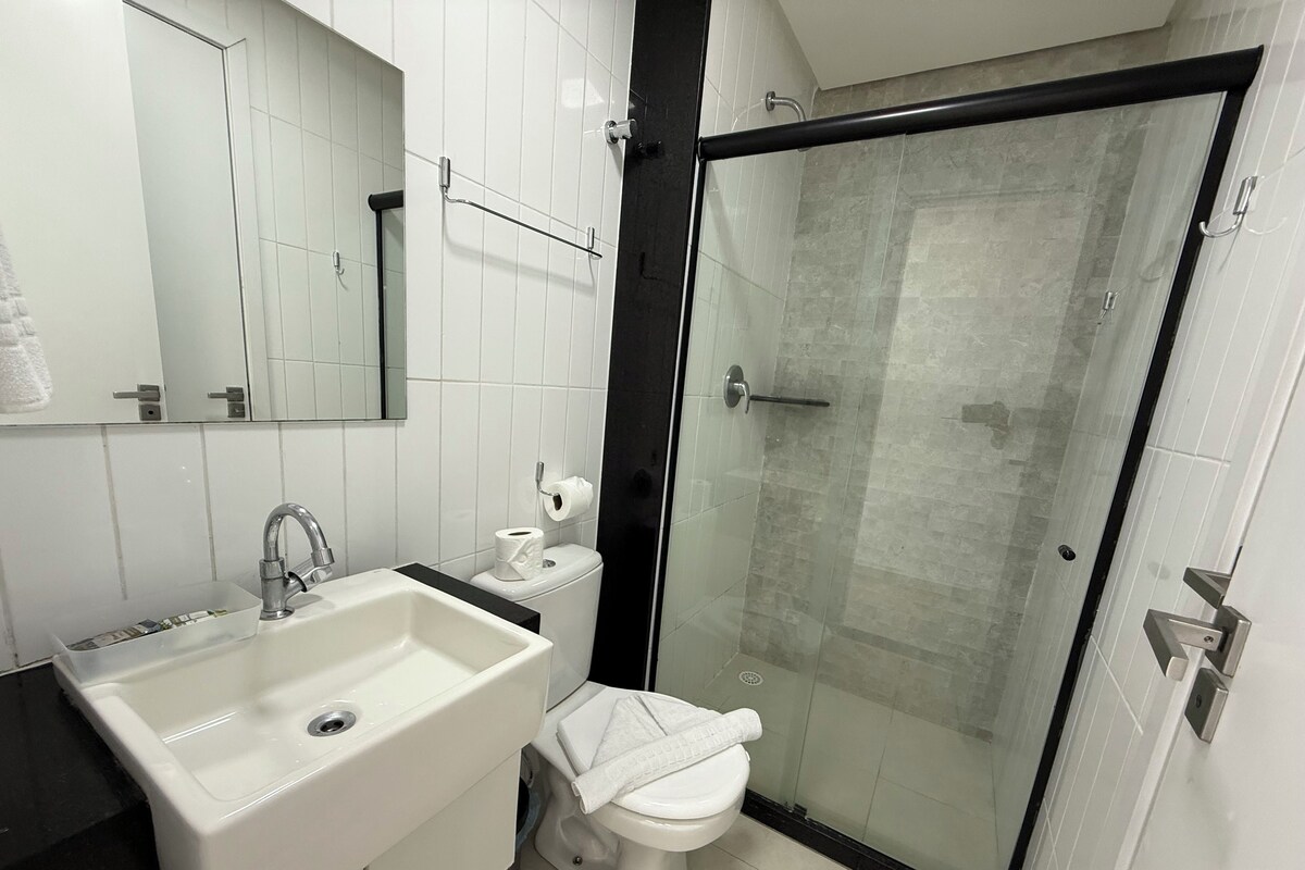 A bathroom with a sink, toilet, and glass-enclosed shower.