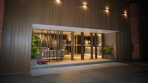 A modern building entrance with a reception desk, a waiting area with chairs, and a cart. - Hotel Barahi Kathmandu (Kathmandu)