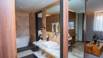 Un baño moderno con un espejo grande, una bañera y un lavabo con tocador.